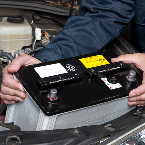 Auto mechanic replacing car battery