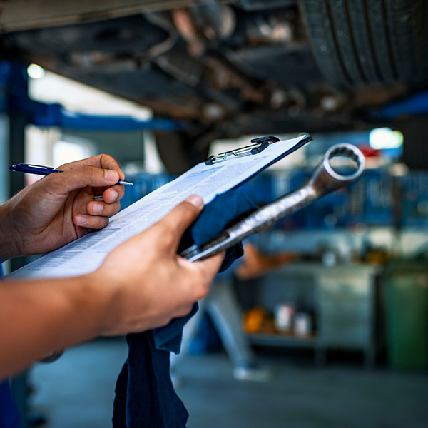 Automotive specialist adjusting an engine