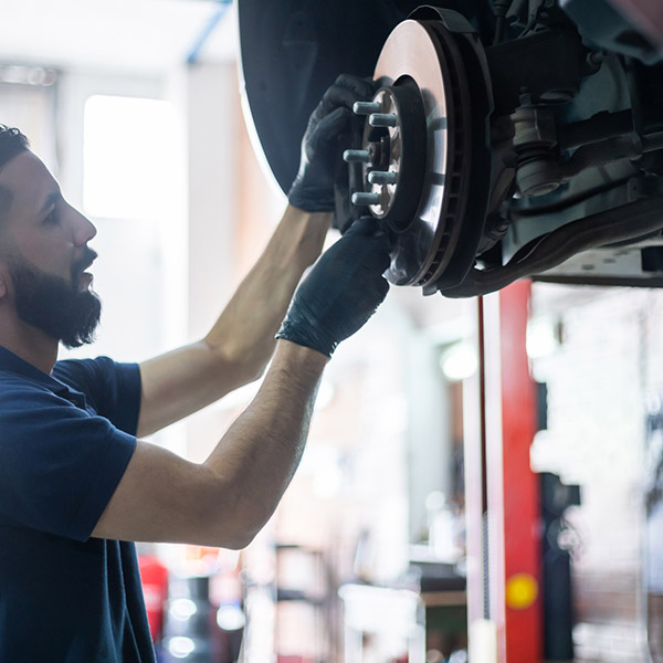 Young mechanic checking the brake disk of a car